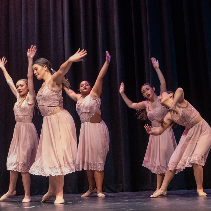 Five contemporary dancers in light pink lace dresses.