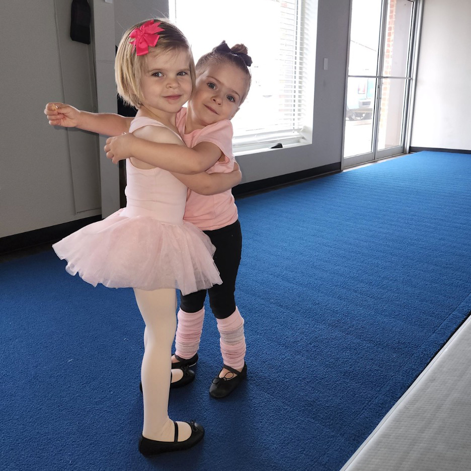 Two young girls in acrobatics class.