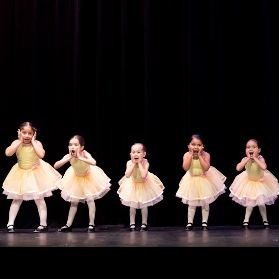 Five tap dancers in yellow costumes.